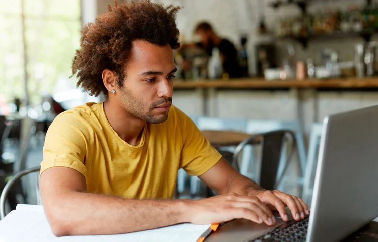 Homem consultando informações financeiras no notebook